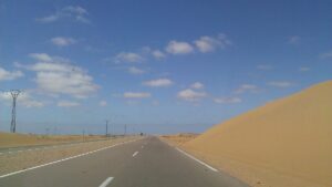 A desert highway crossing sand dunes in the Sahara