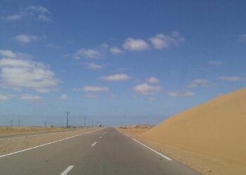 A desert highway crossing sand dunes in the Sahara